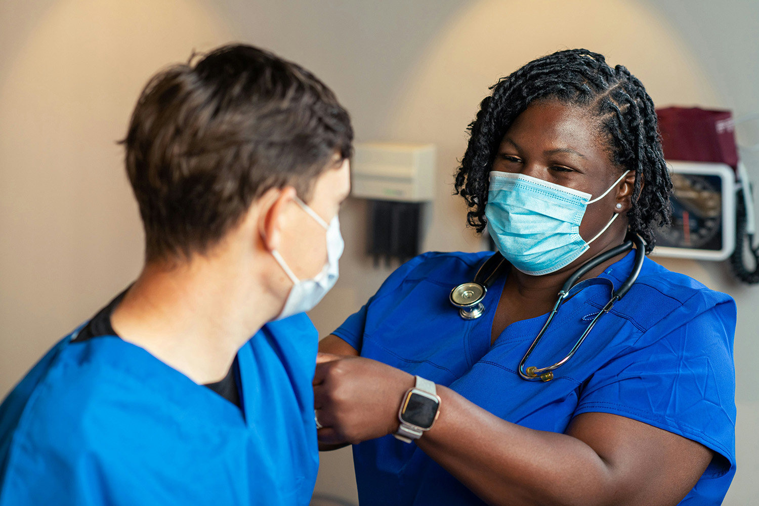 Health care provider places a bandage on patient.